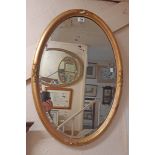 A 32" antique gilt gesso framed bevelled oval wall mirror - slight damage