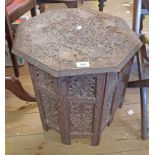 An 18" Indian hardwood Moorish style occasional table with profuse vine scroll carved decoration