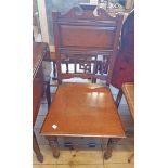 A 19th Century mahogany hall chair with pierced splat and panel back, set on turned front legs - old
