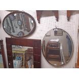 Two vintage bevelled oval wall mirrors comprising one frameless, the other oak framed