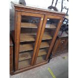 A 3' 2" polished oak book cabinet with four adjustable shelves enclosed by a pair of glazed panel