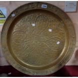 A large brass tray with embossed leaf and cross decoration