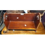 A 16 1/4" early 20th Century stained walnut table-top book shelf with flanking pierced handles,
