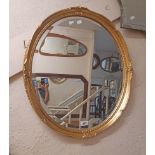 A modern gilt framed bevelled oval wall mirror