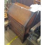 A 30" 20th Century oak bureau with part fitted interior and four drawers under, set on bracket