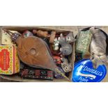 A box containing assorted collectable items including old advertising tins, cat figurines, bellows