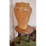 A 20th Century polished oak circular occasional table - sold with an "Ali Baba" laundry basket and a
