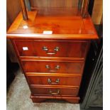 A 17" reproduction yew and cross banded bedside chest of four long drawers, set on bracket feet -