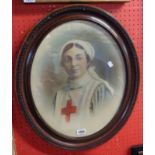 A pair of moulded wood oval framed tinted photographic portraits, one depicting a Red Cross Nurse,