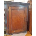 A 31" late Georgian stained oak wall hanging corner cupboard with dental cornice and scalloped