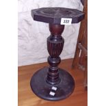 A 15 1/2" high stained wood jardiniere stand with carved top and reeded pillar