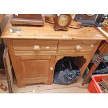 A 34 1/2" 20th Century waxed pine kneehole desk with two frieze drawers and panelled cupboard door