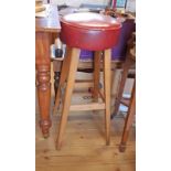 A vintage bar stool with red leatherette upholstered seat, set on square tapered supports