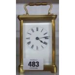 A brass and bevelled glass cased carriage timepiece with plain white dial, platform escapement and