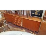 A 7' 4" retro teak effect sideboard with four central drawers and flanking sliding drawers, set on