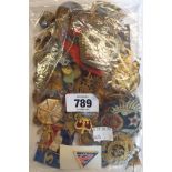 A bag containing a collection of military and other cap badges