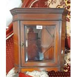 A 15" walnut and strung wall hanging corner cabinet with canted sides and bevelled glazed panel