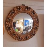 A decorative gilt plaster framed convex wall mirror with pierced border