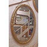 An old gilt gesso framed bevelled oval wall mirror with later finish
