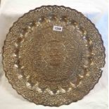 An antique Indian Kutch white metal embossed charger, decorated with floral motif and pierced border