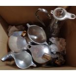 A box containing a Piquot Ware set, a moulded glass claret jug, etc.