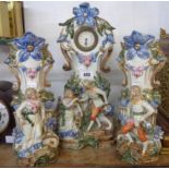 An early 20th Century German decorative porcelain clock garniture with courting couple figures and