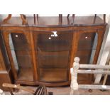 A 4' 7" figured walnut and mixed wood serpentine front display cabinet with two glass shelves