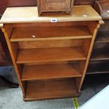 A 26 1/2" golden oak four shelf open bookcase, set on rounded plinth base