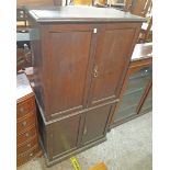 A 30" early 20th Century stained oak cupboard with later glass shelves enclosed by two pairs of