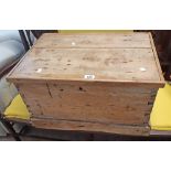 A 24" antique stripped pine lift-top box with flanking iron carying handles - worn and tired