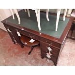 A 4' 6" 20th Century mahogany twin pedestal desk with green leatherette inset top, three frieze