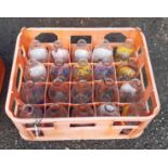 A vintage Unigate plastic milk crate containing twenty assorted advertising milk bottles