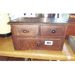 A stained mixed wood table-top three drawer chest