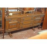 A 5' 5" Old Charm polished oak sideboard with three central drawers and flanking linen fold panelled