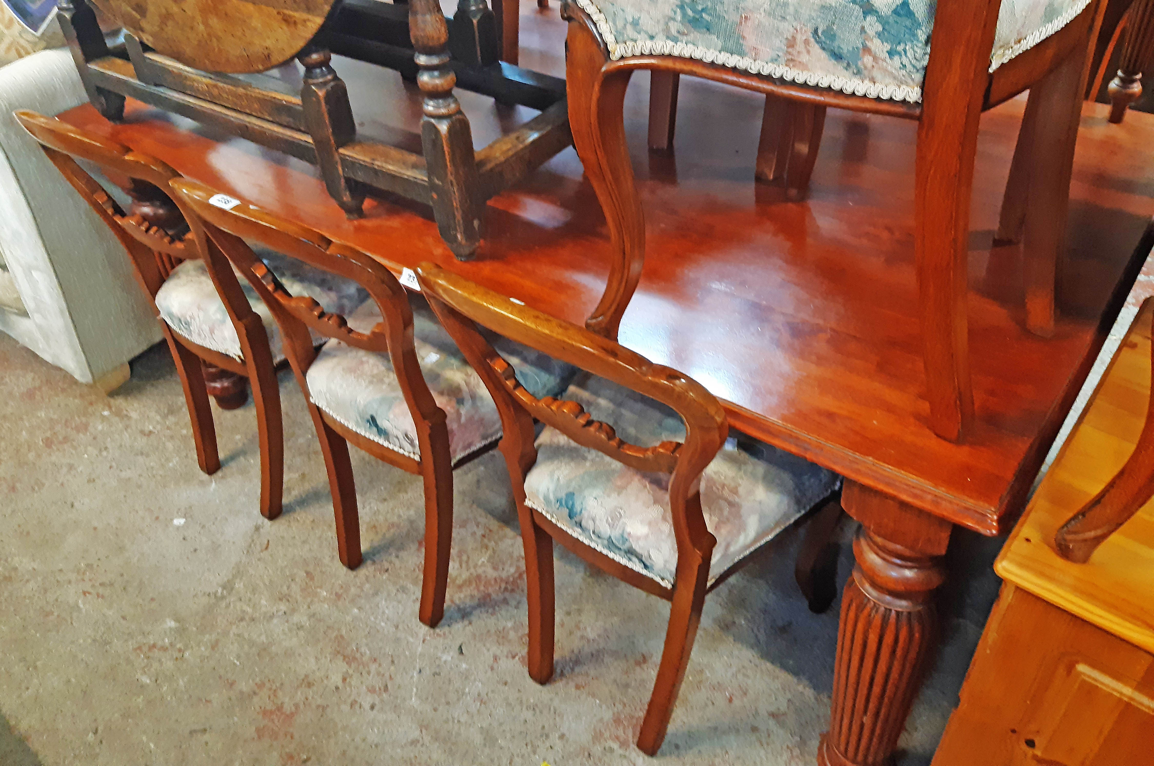 A 6' reproduction mahogany dining table with moulded top, set on heavy turned and reeded legs