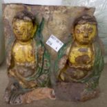 An antique Oriental terracotta tile with two high relief glazed figures of Buddha