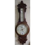 A late Victorian carved oak cased banjo barometer/thermometer with printed scale and dial and