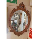 A decorative gilt platster framed oval wall mirror