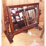 An early 20th Century varnished oak swing dressing table mirror with bevelled oblong plate, set on