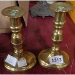 A pair of antique brass ejector candlesticks
