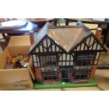 A vintage large wooden dolls house of mock tudor style in need or restoration - sold with a box