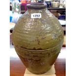 An antique Chinese pottery vase with olive green glaze and ribbed decoration
