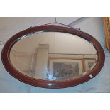 An Edwardian walnut and strung framed bevelled oval wall mirror