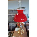 An Aladdin No. 23 Single burner oil lamp with "Loxon" chimney and red dome shaped shade