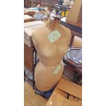 A vintage dressmaker's mannequin on later wooden base