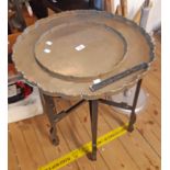 A 1920`s Chinese brass double tray top table with remains of text and other incised decoration,