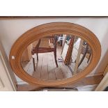 A modern moulded softwood framed oval wall mirror