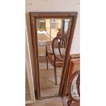 A campaign style bevelled oblong wall mirror with metal corners and narrow plate