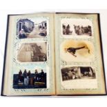 An early 20th Century postcard album containing a collection of postcards including fisherfolk, dogs