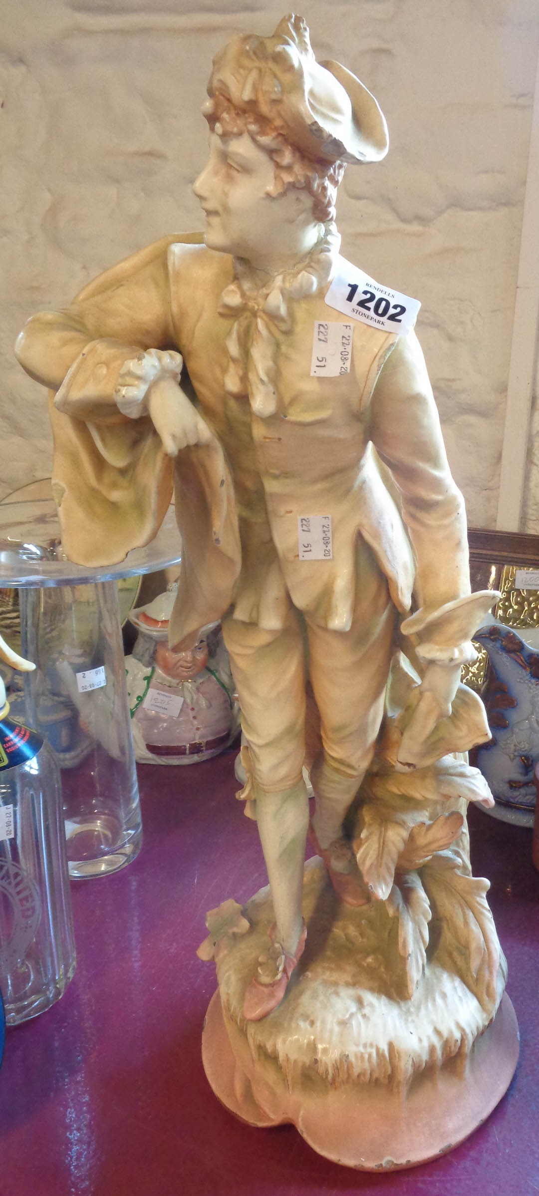 A large continental pottery figurine of a gentleman in period dress - a/f
